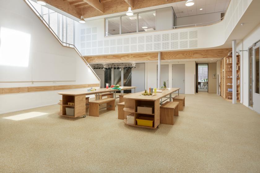 A large room with an upper level and furniture on the ground floor