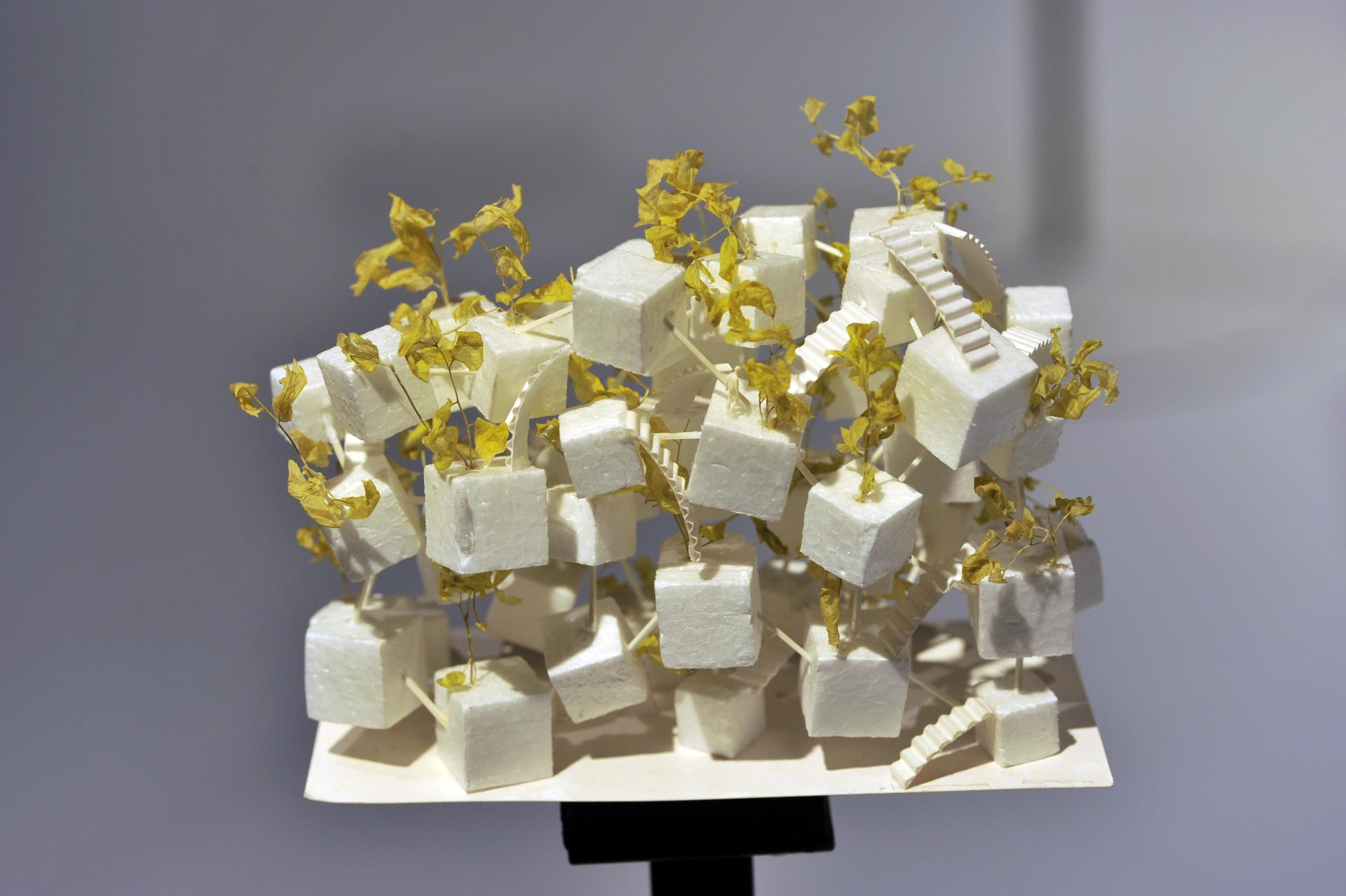 Architectural model by Sou Fujimoto featuring abstract white structures with yellow foliage, exhibited at Japan House London.