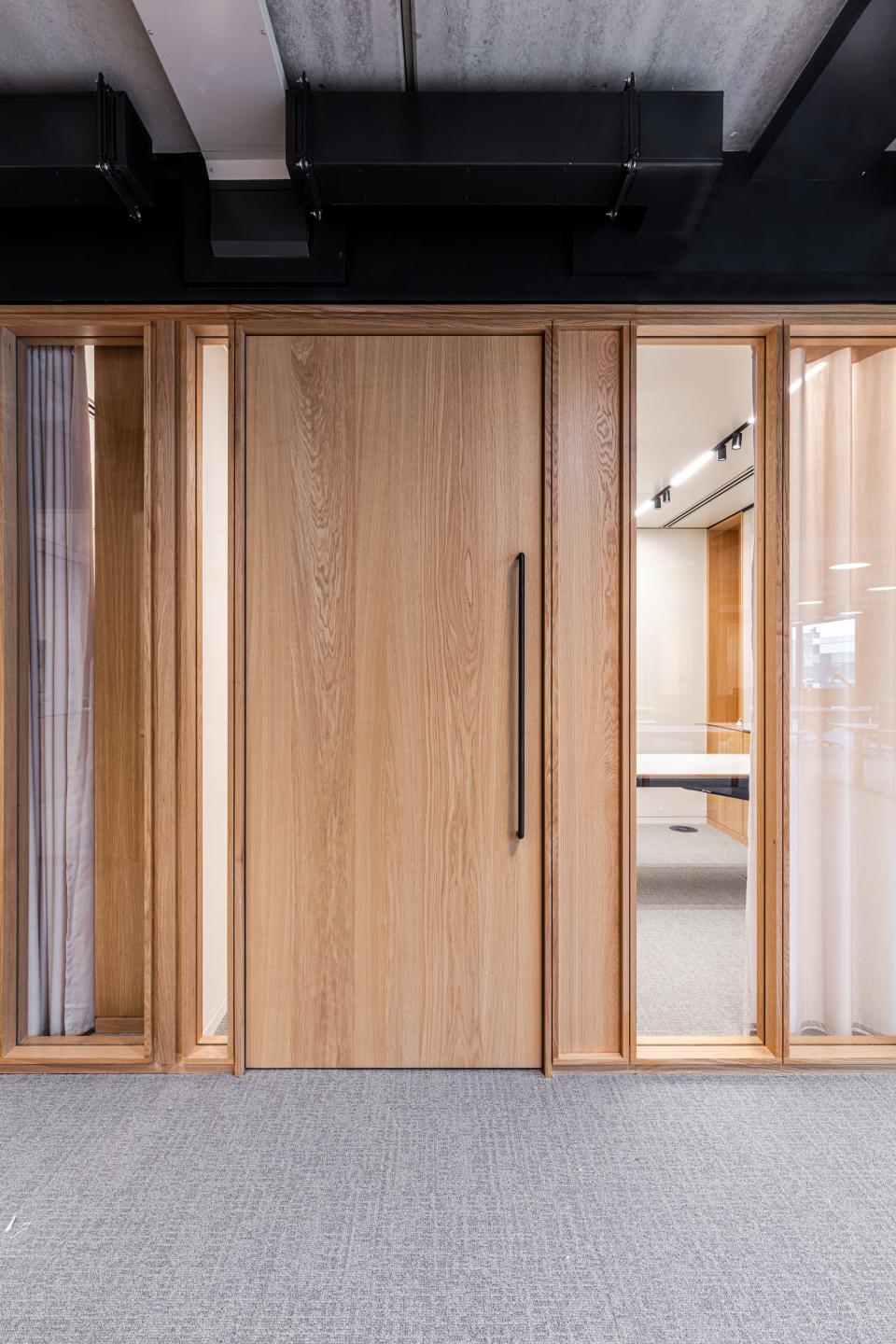 Bespoke timber-framed glazed partitioning and doors at Boston Consulting Group's London office design.