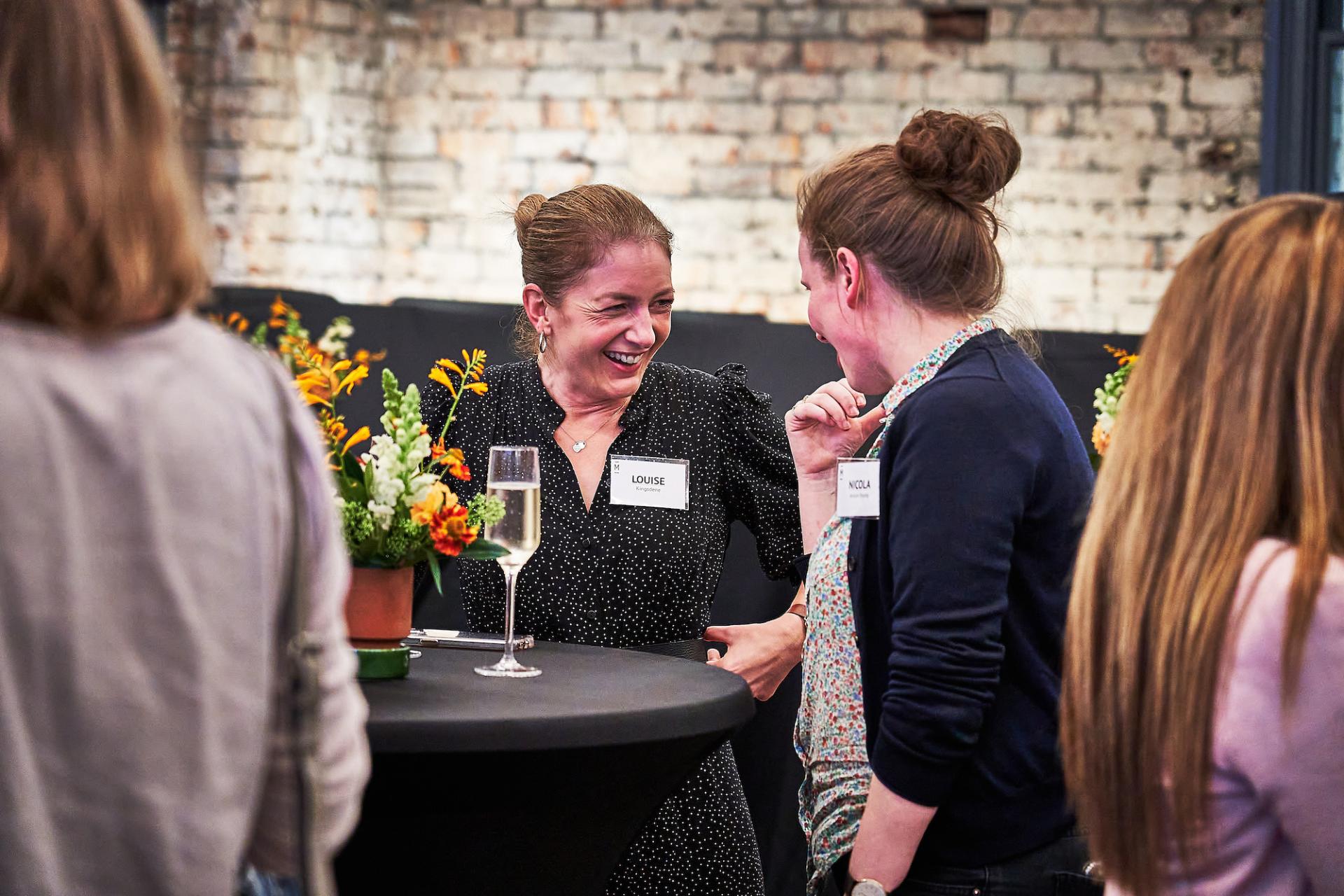 Two women engaged in lively conversation at the 42 Gathering event, celebrating the podcast 42 Roles in the Built Environment.