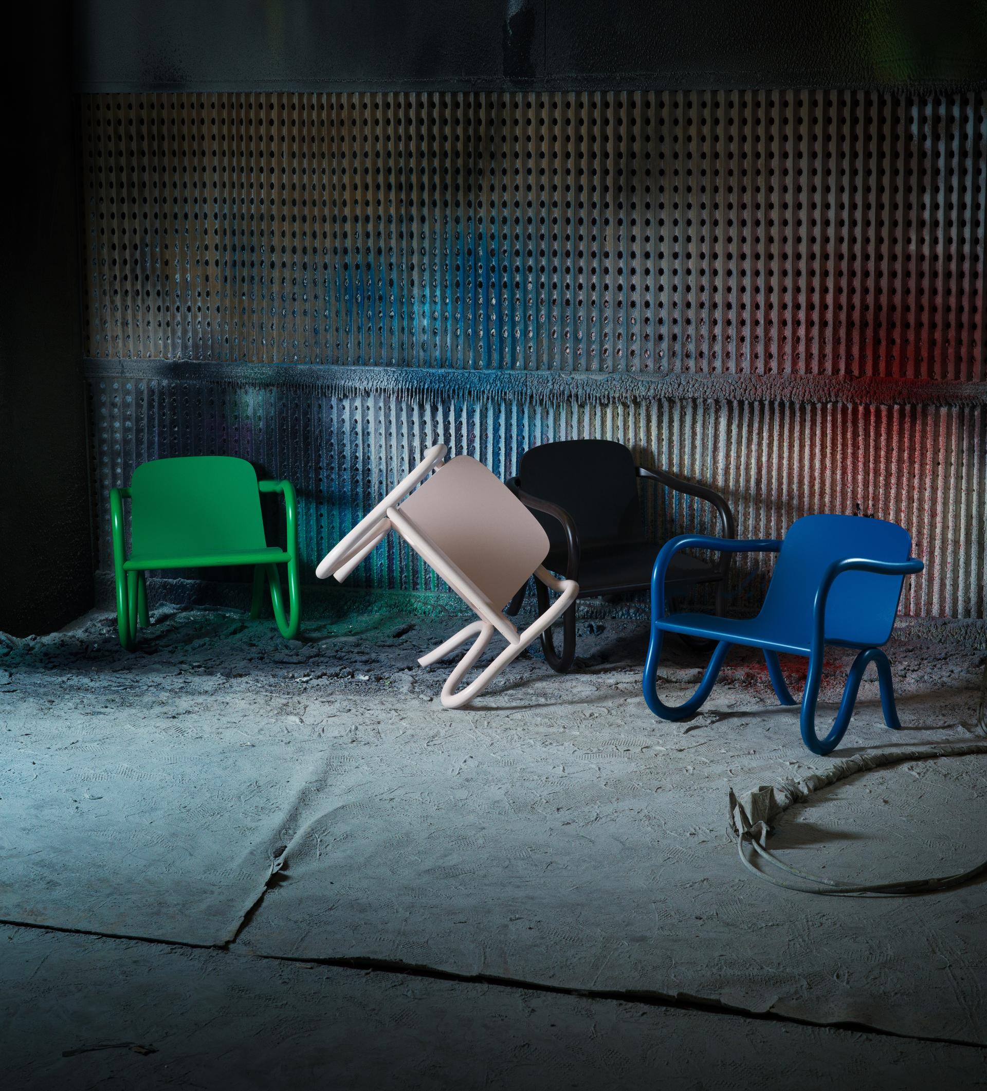 Bespoke chairs from the Kolho collection by Matthew Day Jackson, showcasing vibrant colors against a dramatic industrial backdrop.