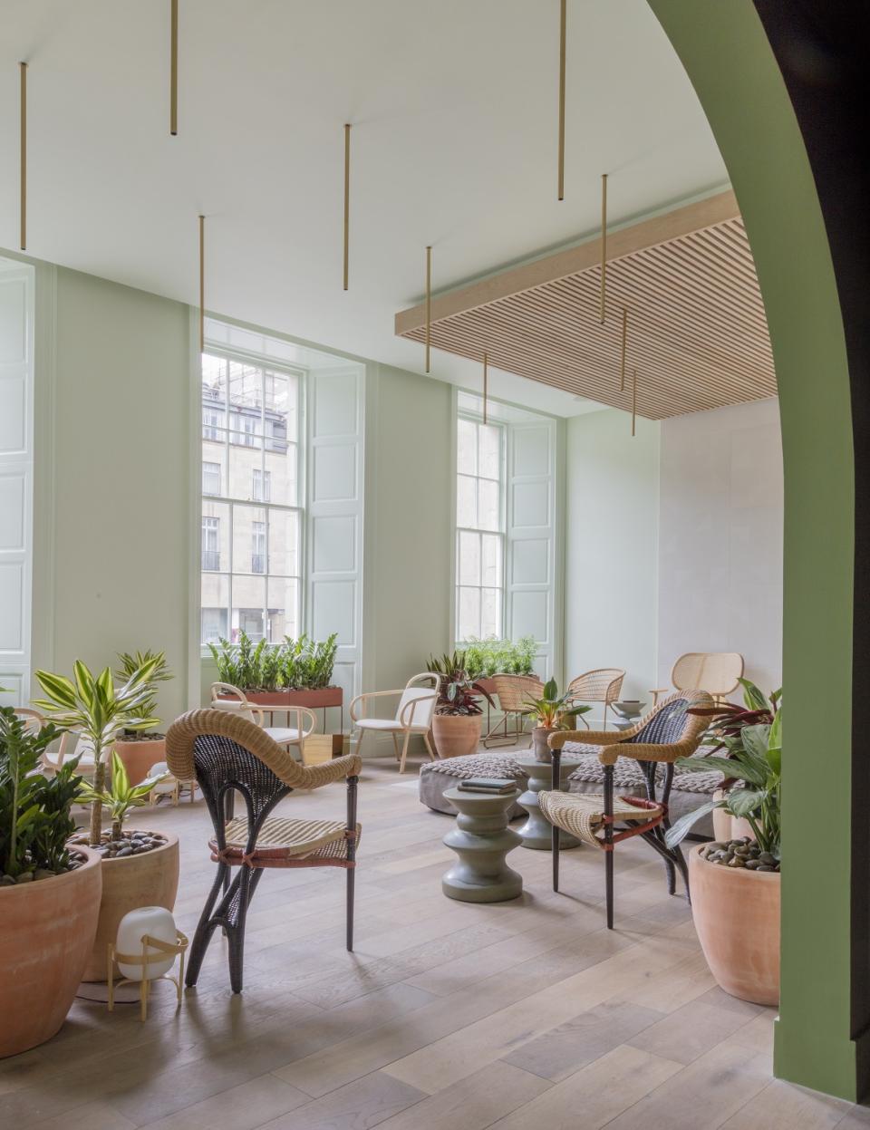 Stylish lounge area at Eden Locke, Edinburgh, featuring luxurious smoked oak flooring and vibrant greenery.