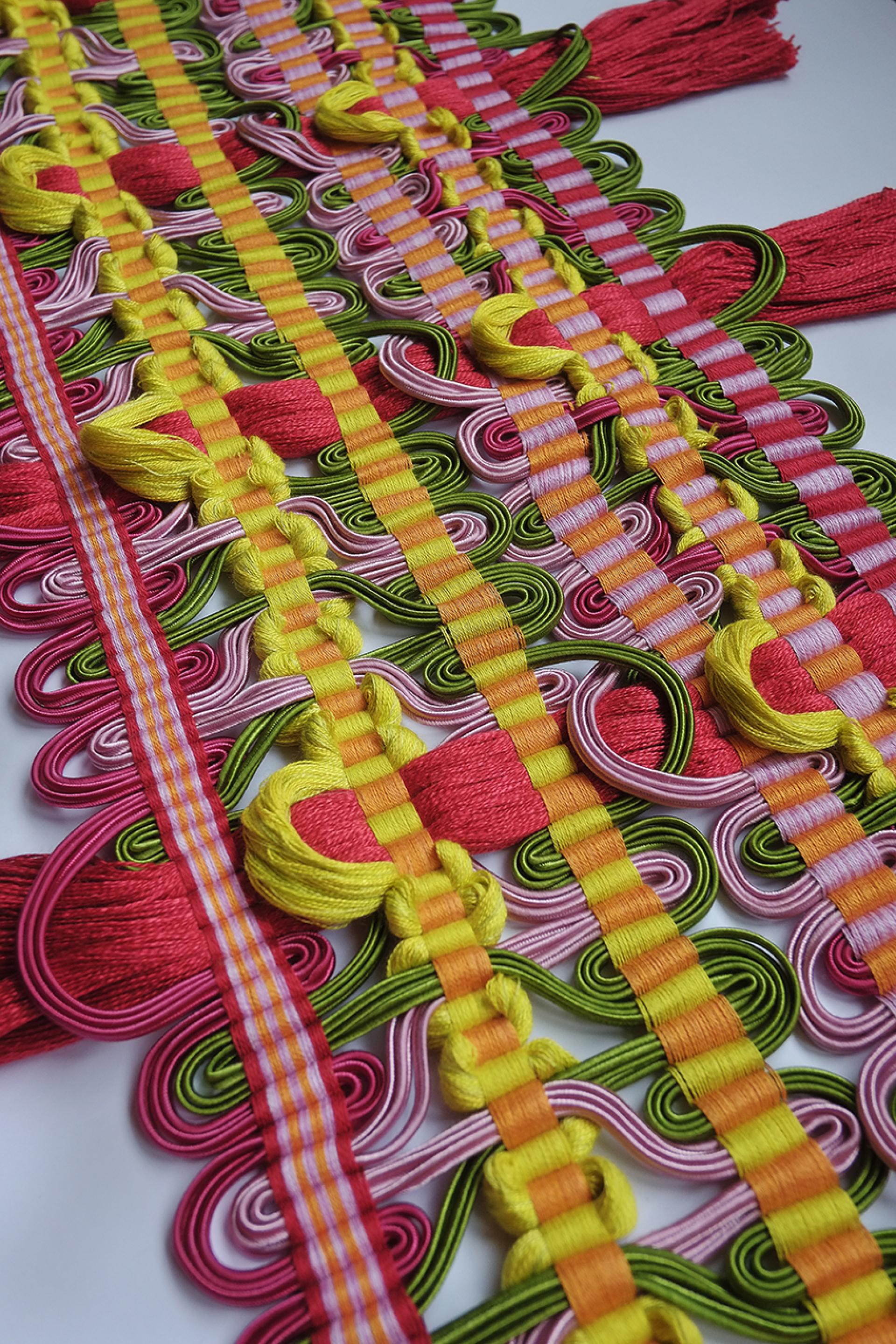 Colorful hand-woven passementerie artwork featuring intricate patterns and vibrant threads by Elizabeth Ashdown.
