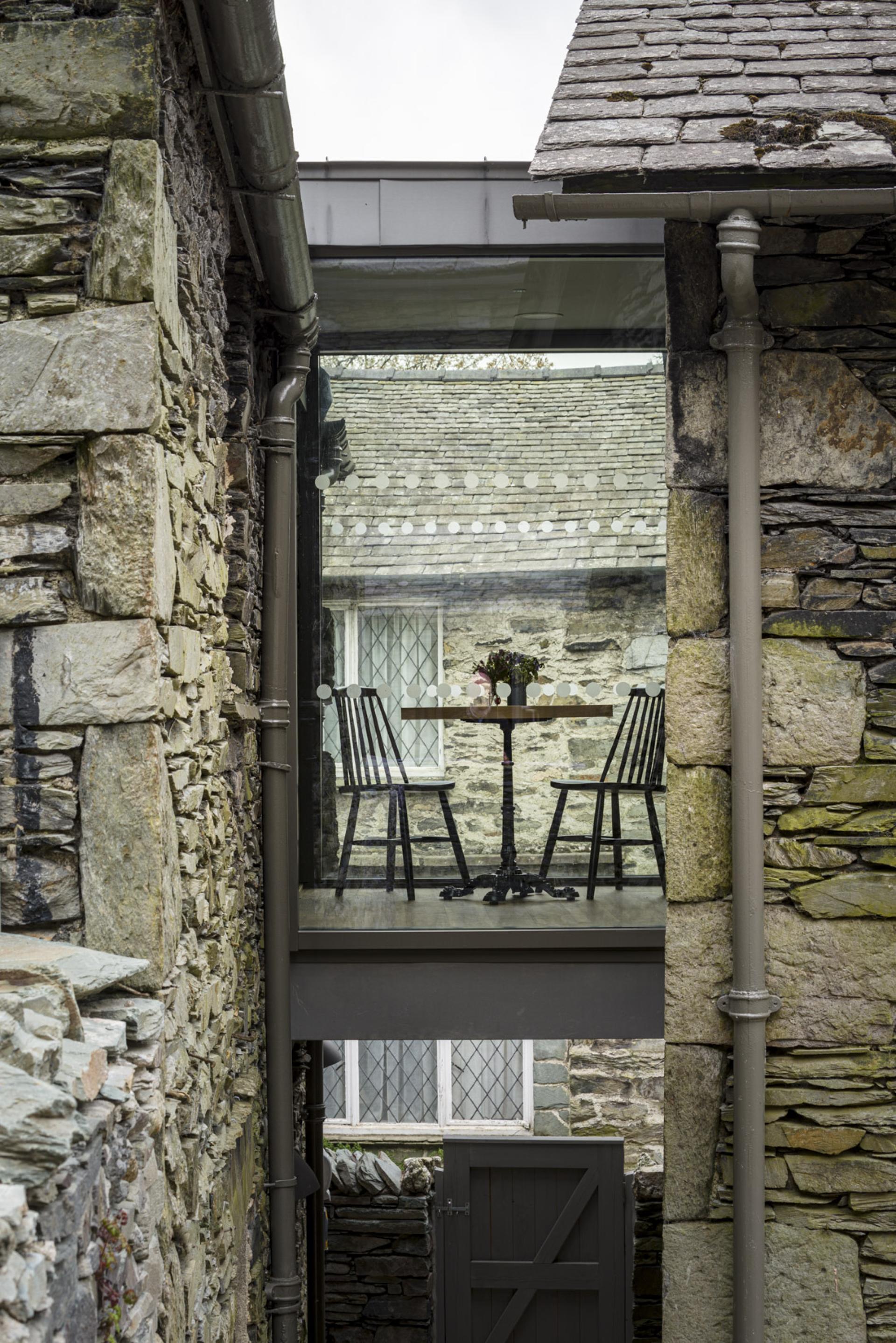 New gallery space at The Museum at Wordsworth Grasmere, featuring a glass bridge connecting historic stone buildings.
