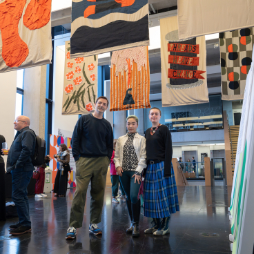 Creative individuals engage with vibrant textile artworks at the Design Council's Design for Planet Festival.