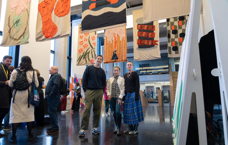 Creative individuals engage with vibrant textile artworks at the Design Council's Design for Planet Festival.