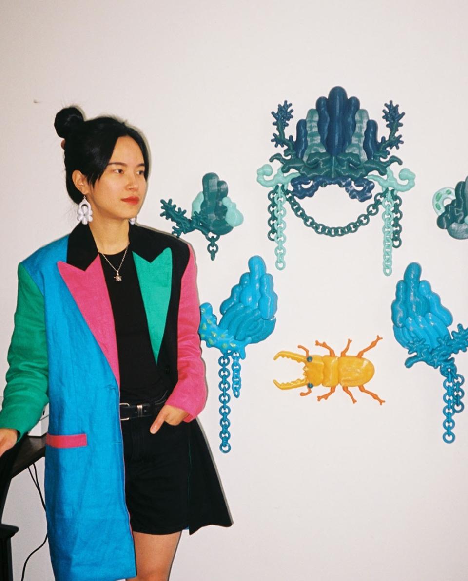 Soorin Shin stands beside vibrant 3D art installations, showcasing her unique style and artistic practice in Glasgow.