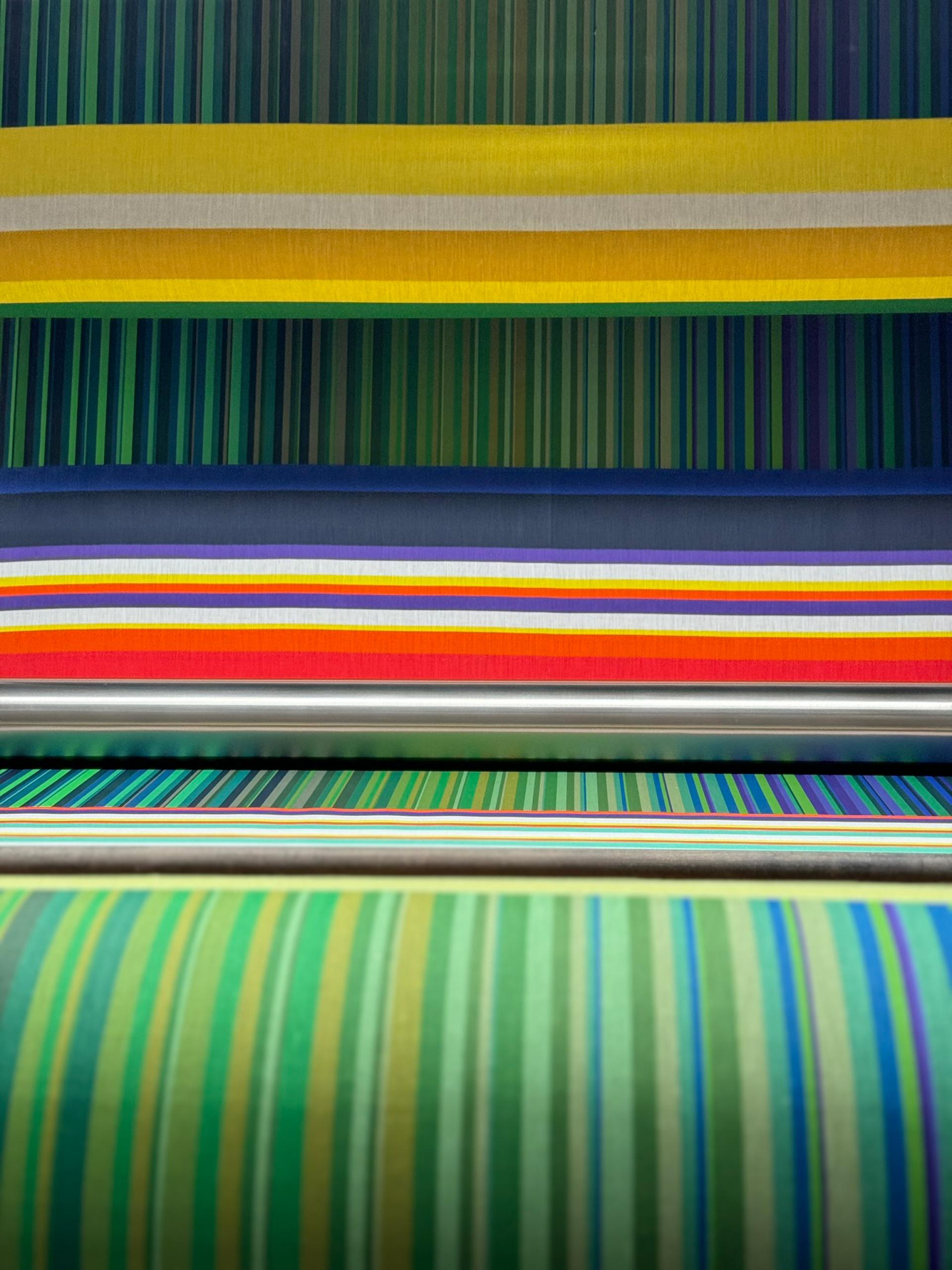 Vibrant textile strips with various colors and patterns, showcasing Margo Selby's unique design style for her installation.