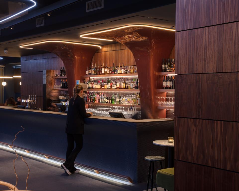 Stylish interior of M'Arks Sky Bar in London featuring a sleek bar, vibrant drinks display, and modern lounge atmosphere.