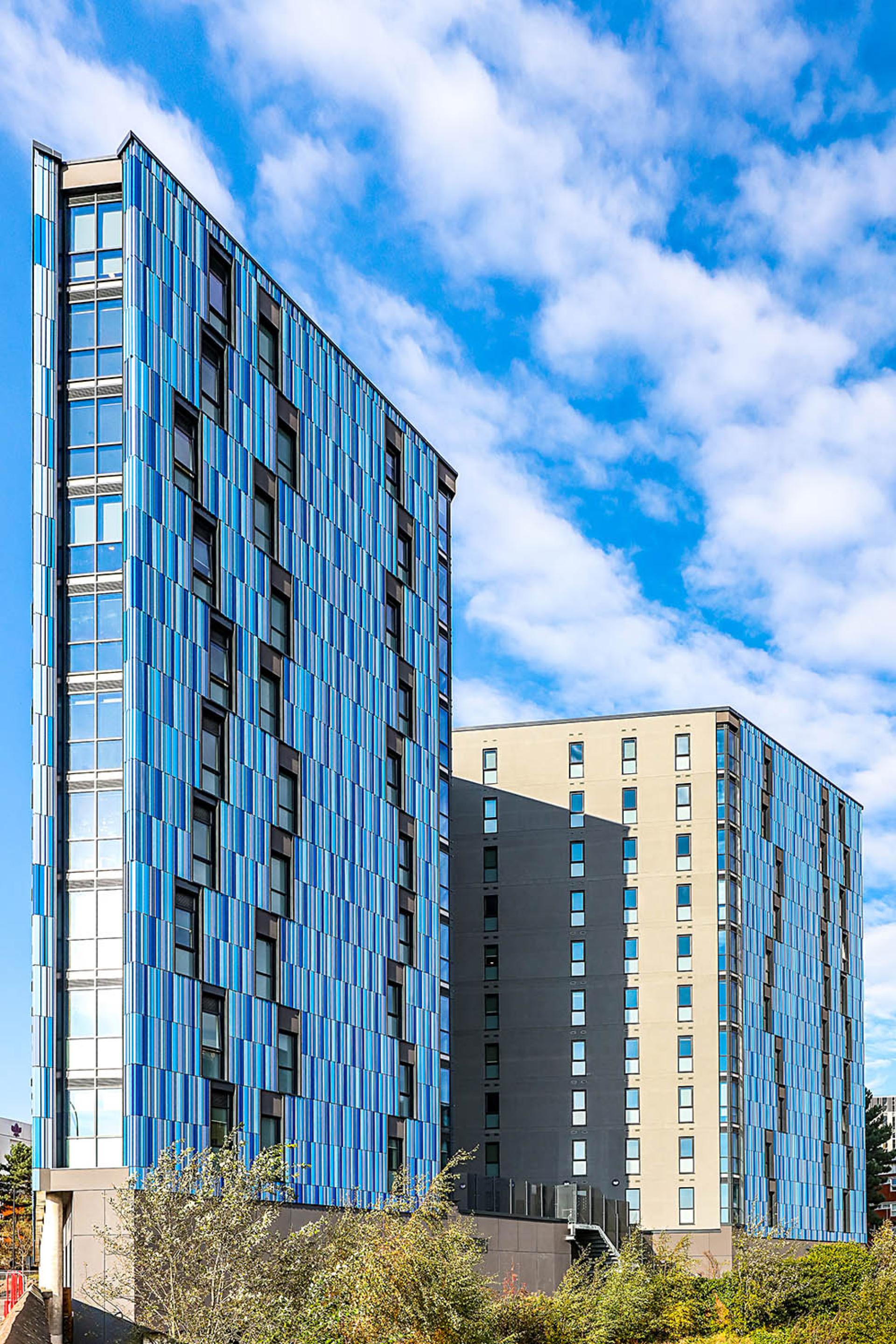 Modern student accommodation buildings at Bath Court, designed by Robert Hirschfield Architects, featuring vibrant blue façades in Birmingham.