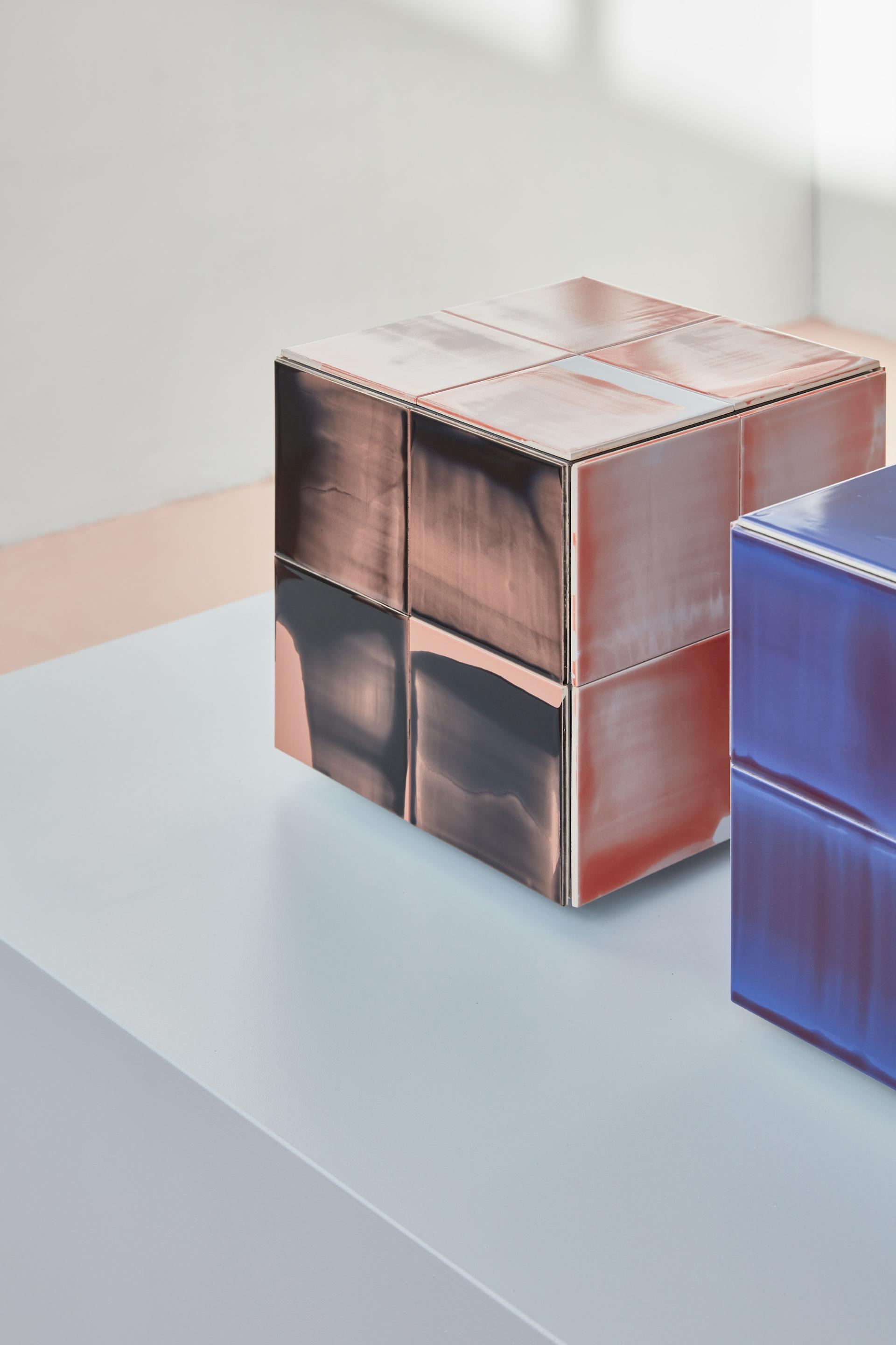 Contemporary ceramic cubes in contrasting colors displayed artfully on a table, highlighting innovative design trends from DDW 2023.