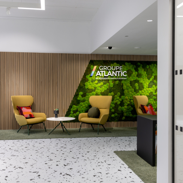 Contemporary office seating area featuring bold terrazzo flooring and vibrant biophilic design elements.