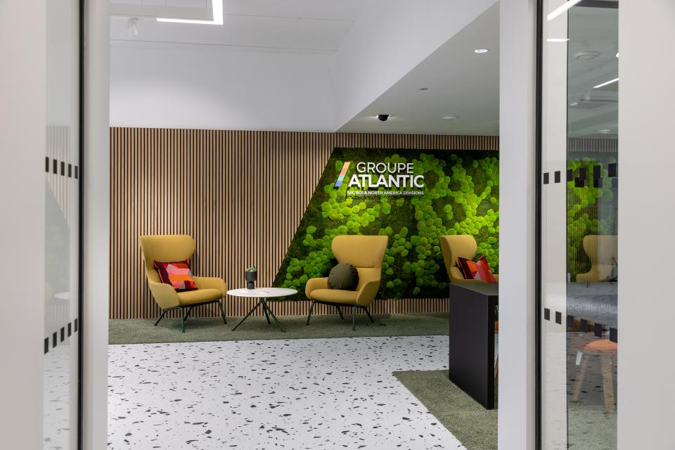 Contemporary office seating area featuring bold terrazzo flooring and vibrant biophilic design elements.