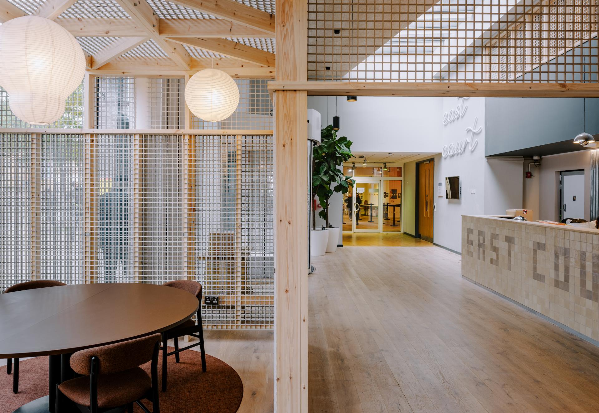 Modern communal space featuring natural materials, ambient lighting, and design elements inspired by Mile End's historic streets.