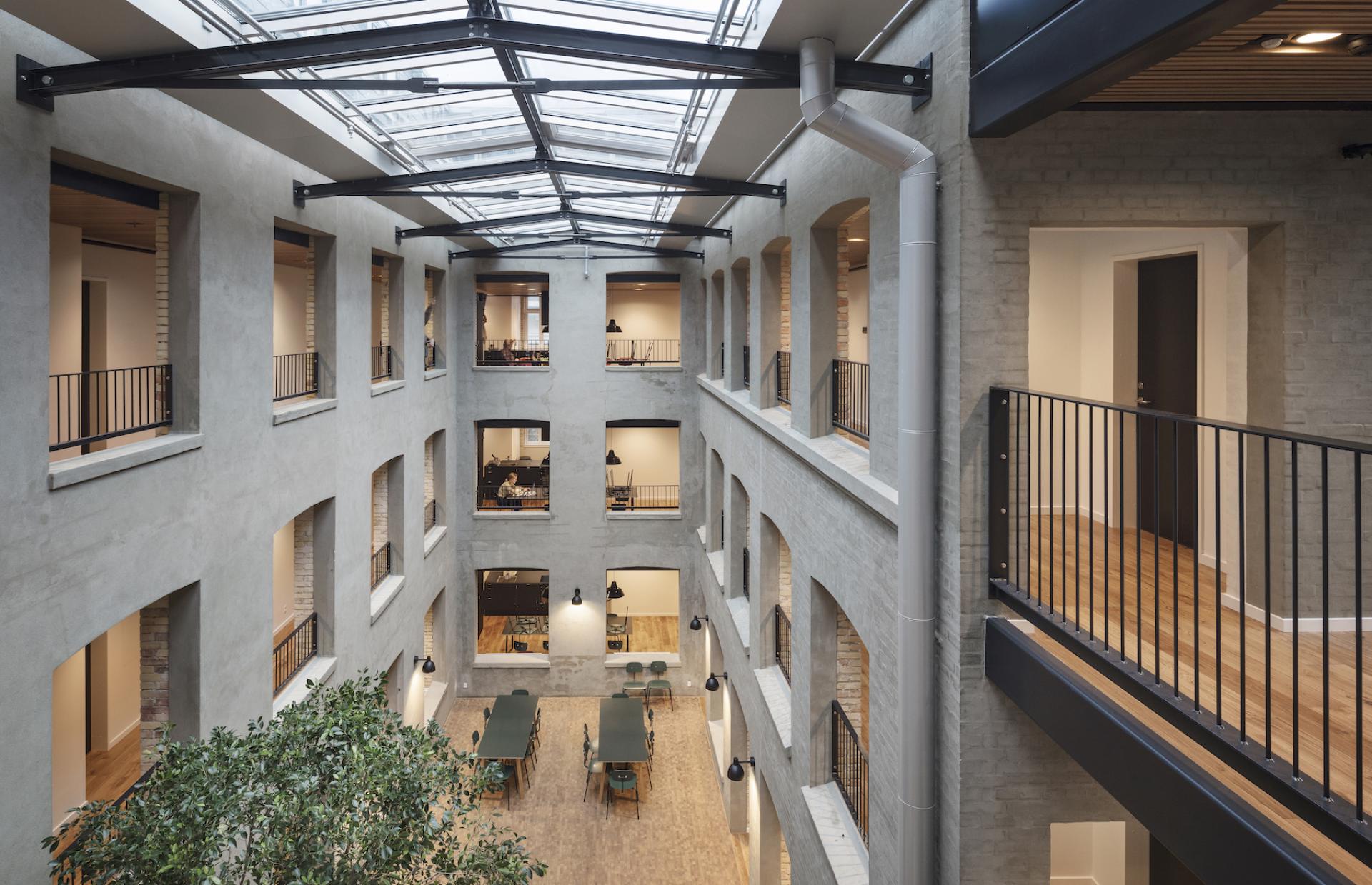 Modern architectural design featuring a spacious interior with skylights and greenery, highlighting sustainable elements from d line.