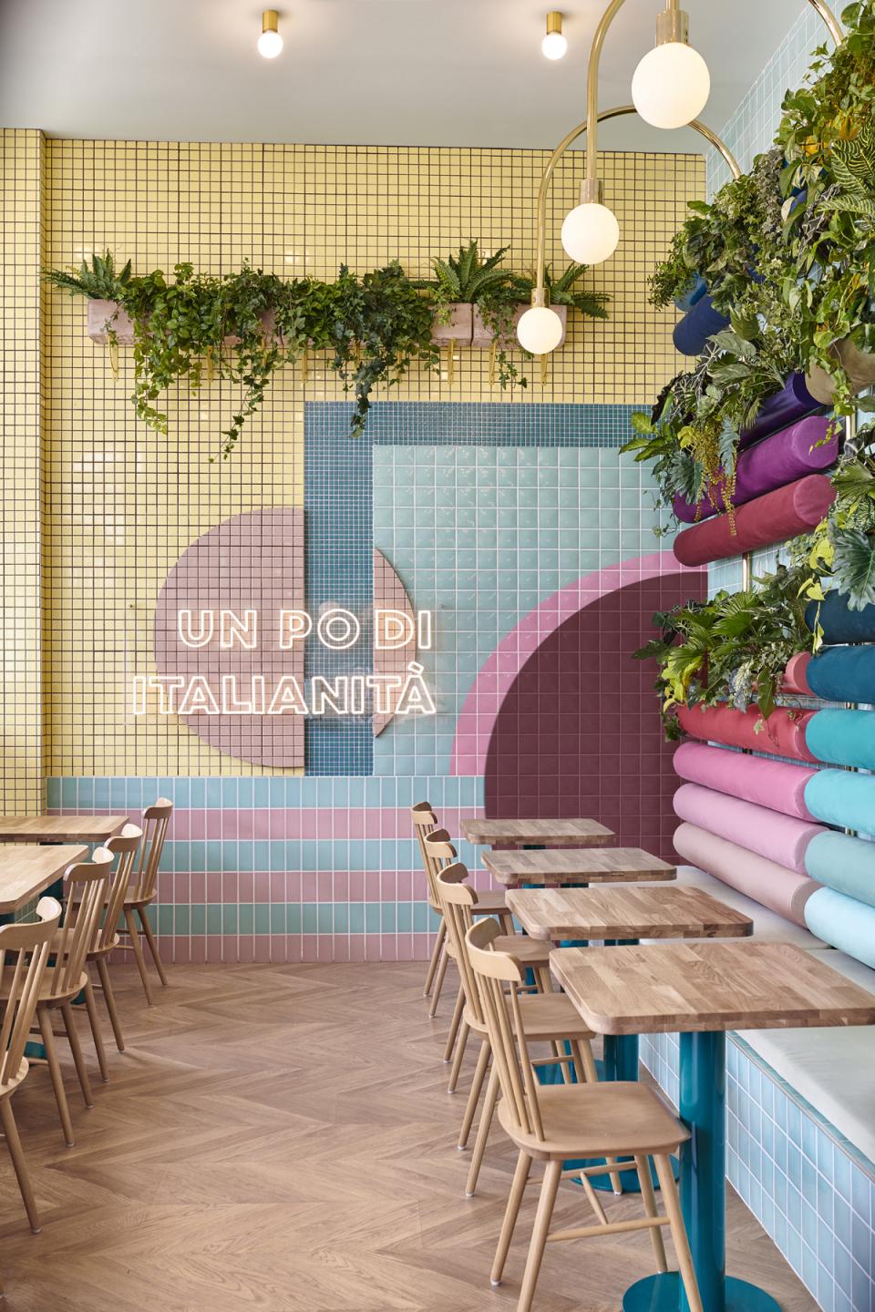 Brightly colored tiled interior of Piada restaurant in Lyon featuring geometric designs and wooden tables, embracing Italian tradition.