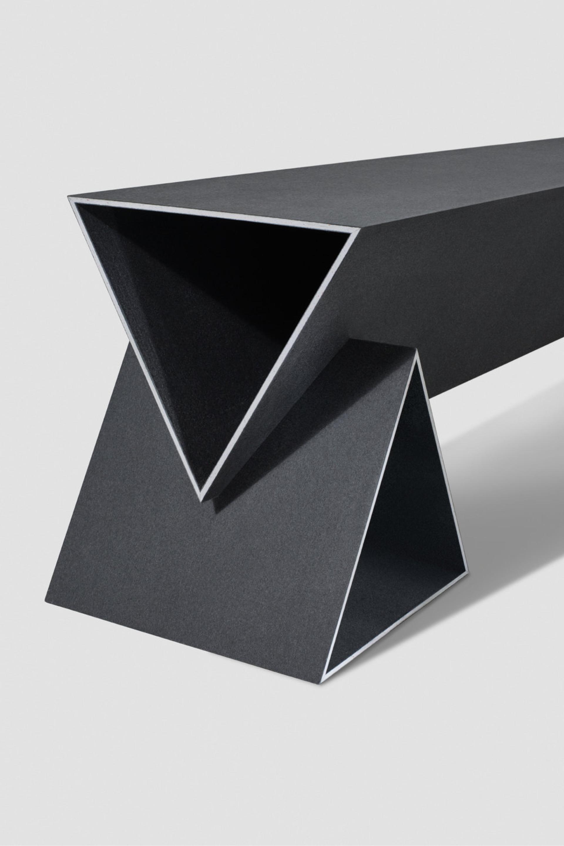 Sleek geometric black bench designed by Monika Swindells, showcasing innovative design and modern materials.