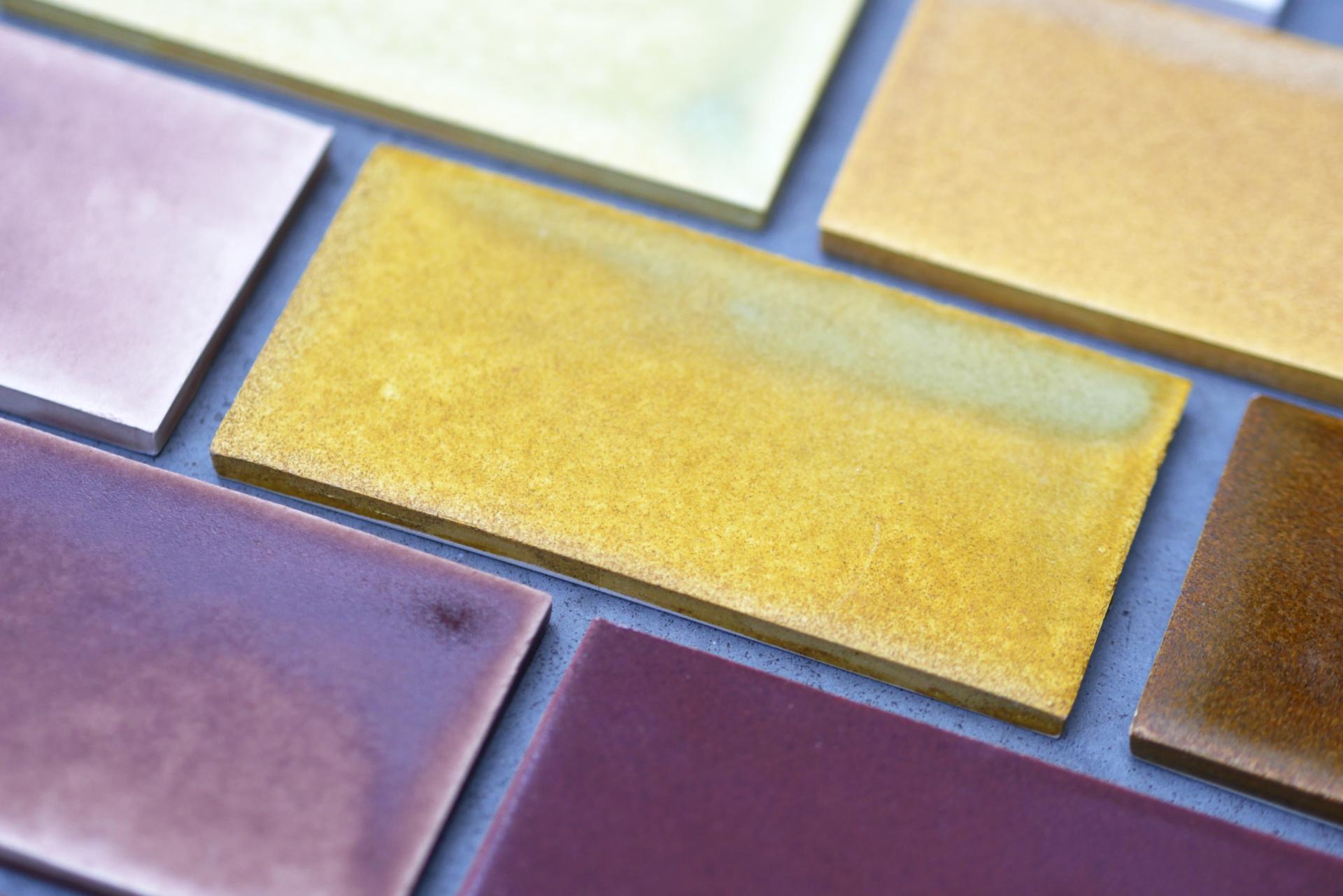 Colorful biomaterial tiles arranged on a surface, showcasing various low-carbon, sustainable design options for 2025.