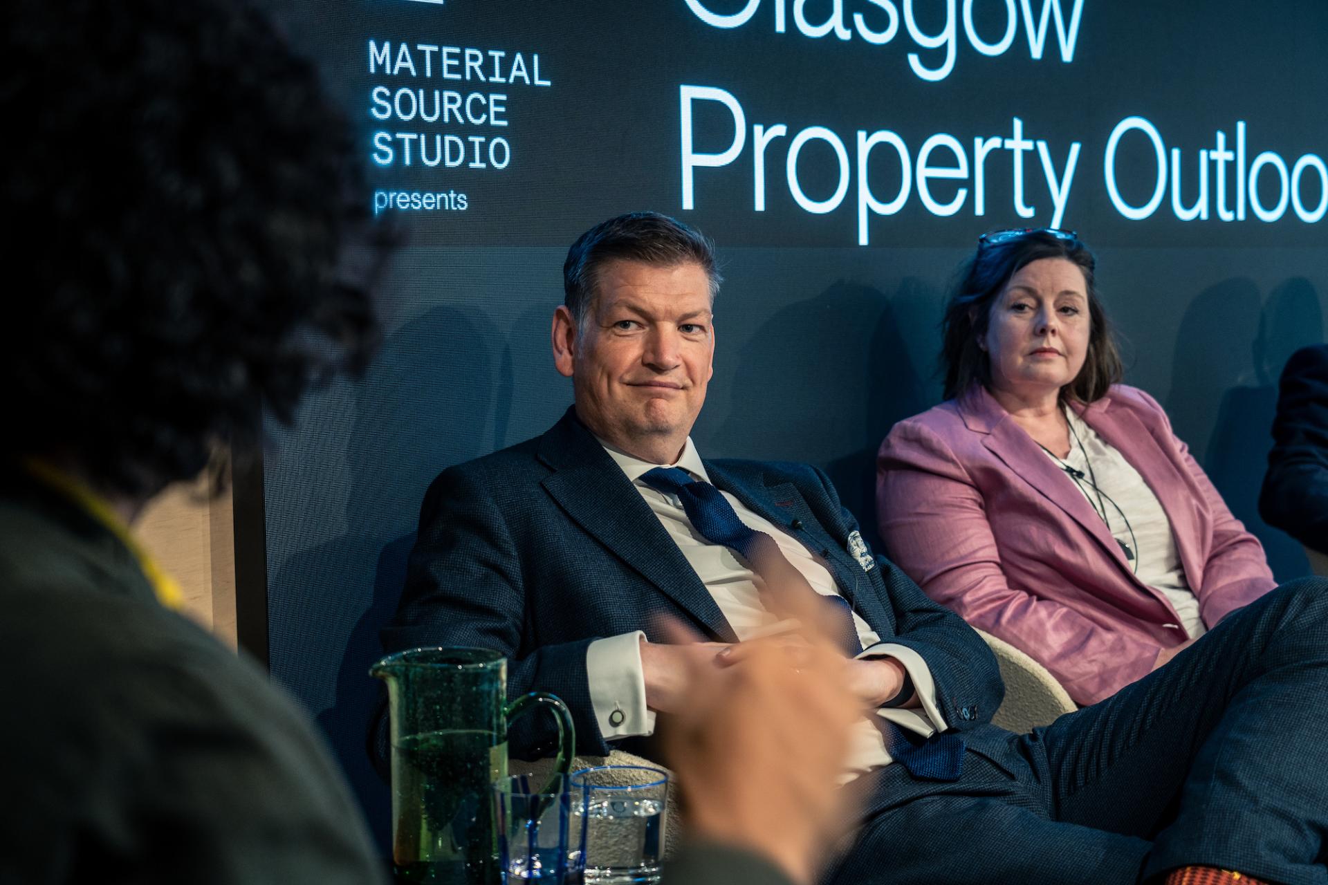 Panel discussion at Material Source Studio focusing on Glasgow's property market outlook, featuring engaged speakers and a contemporary setting.