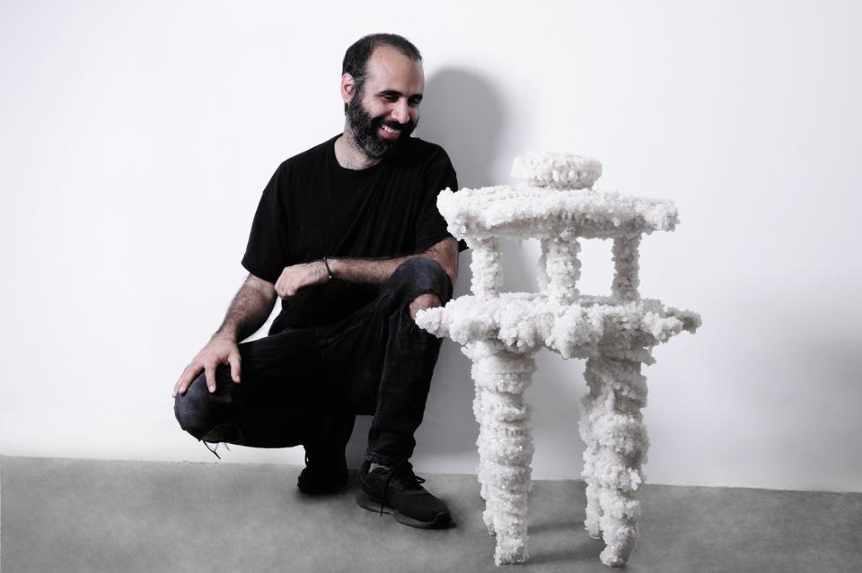 Innovative vegan furniture made from mineral materials, featuring a man proudly displaying a unique, sculptural design.