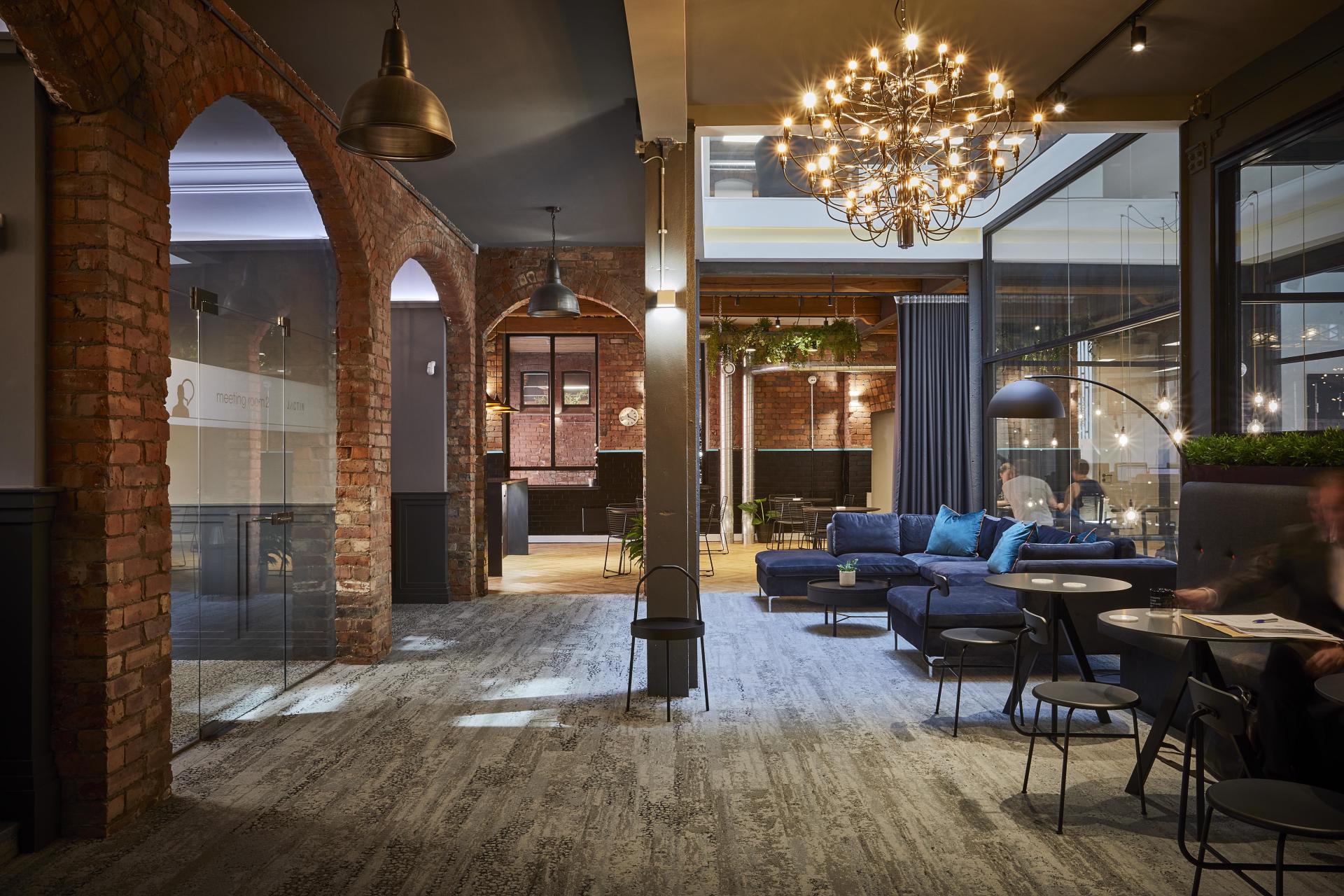 Stylish coworking space featuring exposed brick, modern seating, and integrated coffee areas for a premium experience.