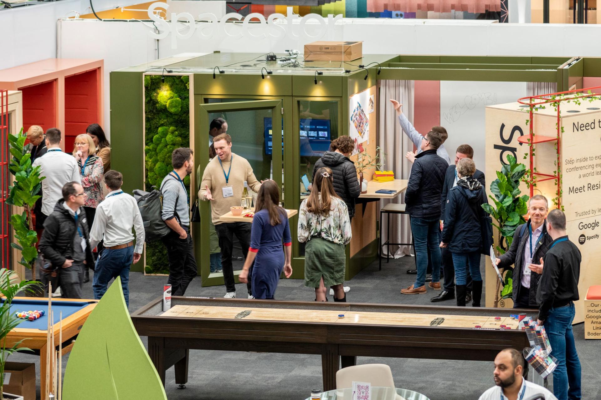 Attendees engage at a vibrant exhibition space highlighting the 'Destination Workplace' theme at the 2023 Workspace Design Show.