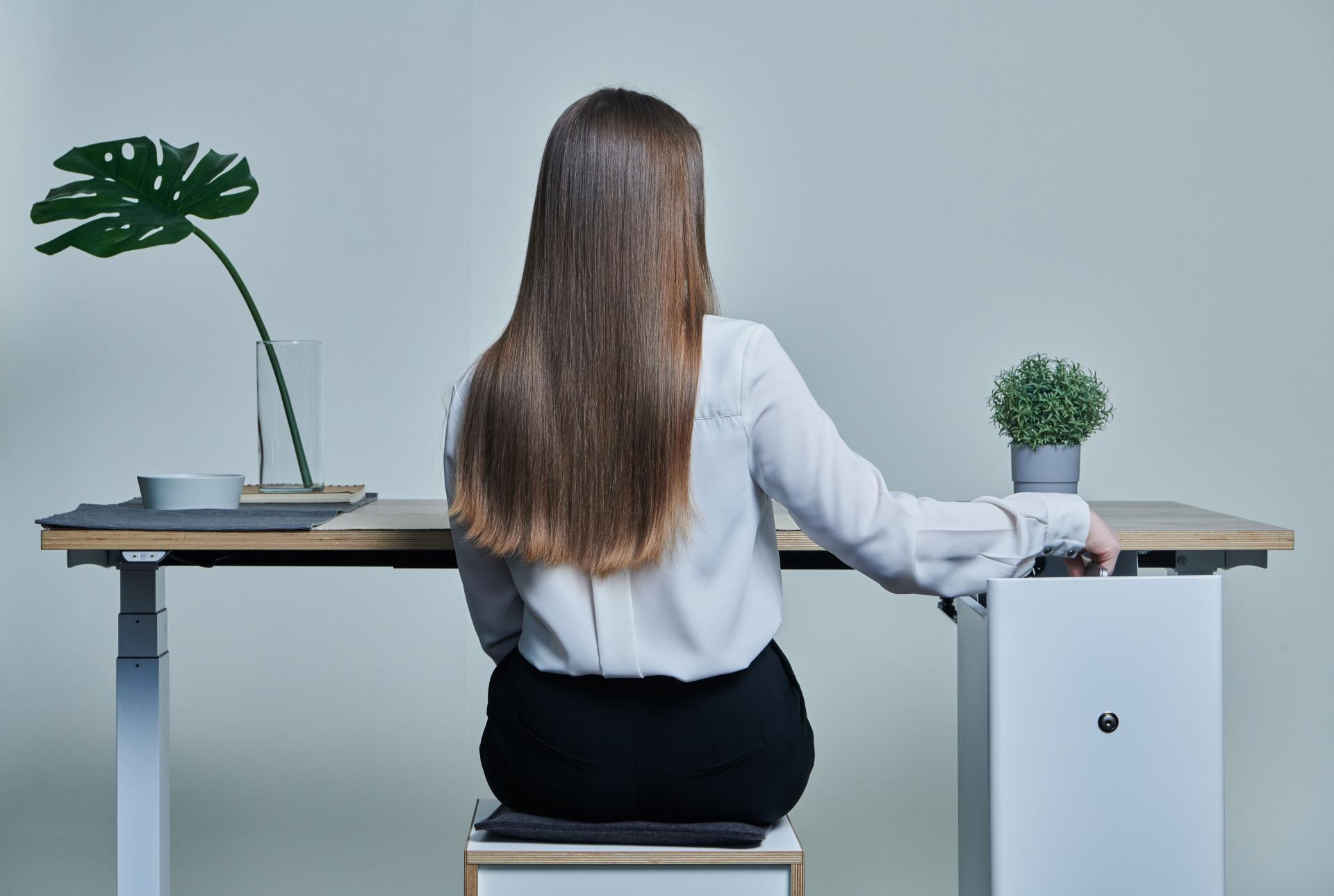 A woman interacts with Bisley's Buddy storage solution at a stylish desk, enhancing personal workspace organization.