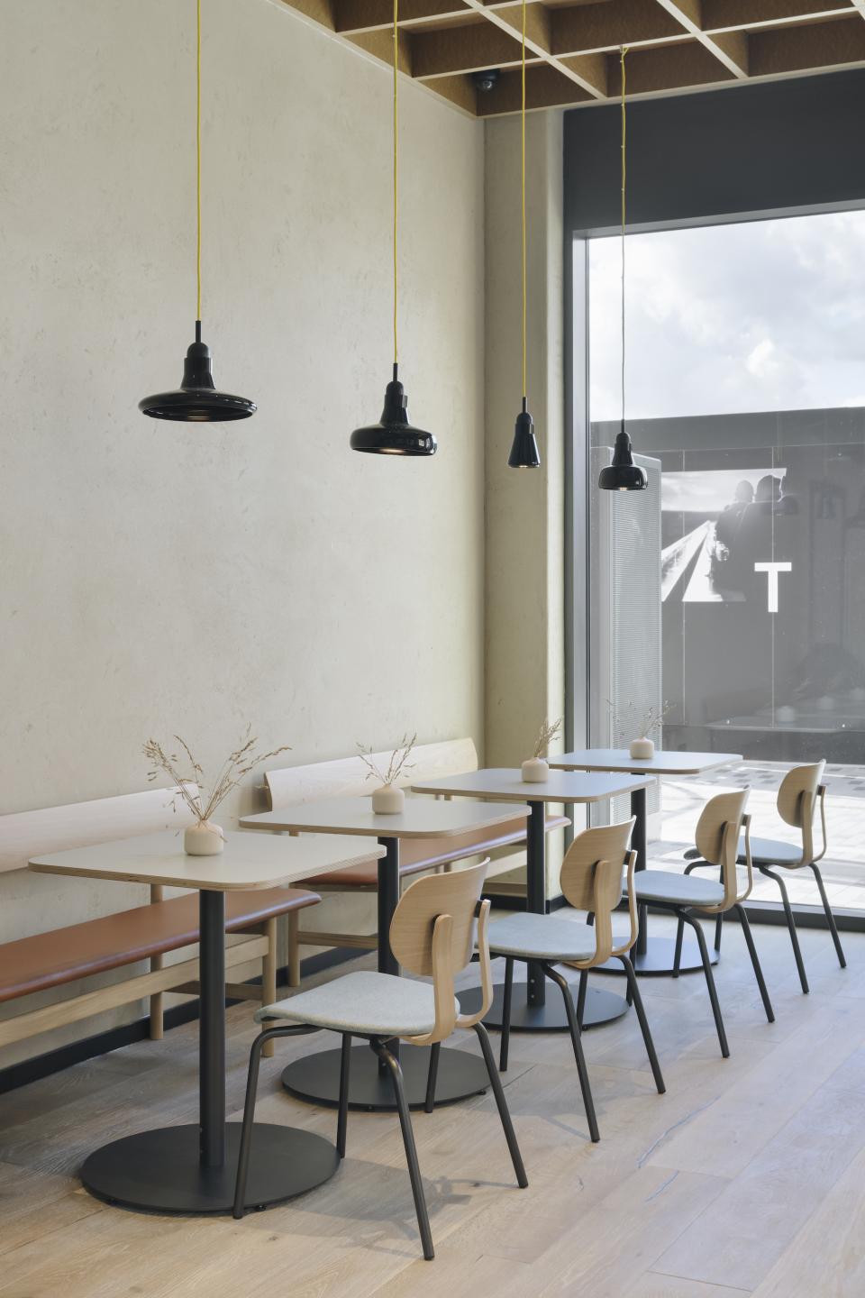 Contemporary dining area featuring wooden tables, stylish chairs, and modern pendant lighting in Globe Point, Leeds.