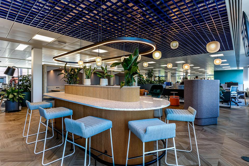Modern office interior design featuring a stylish bar counter, plant decor, and contemporary lighting at Domestic & General's Wimbledon HQ.