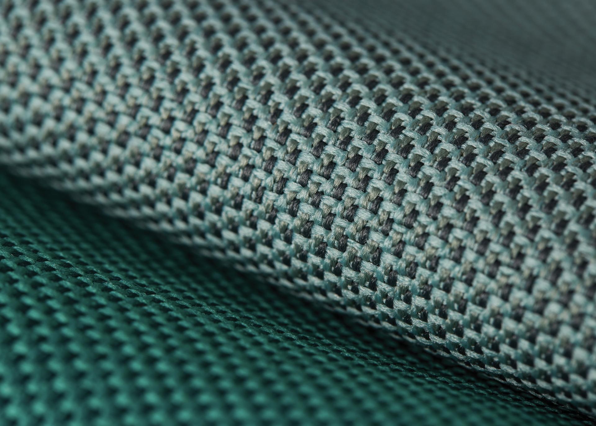 Acoustically transparent textile made from recycled plastic bottles, showcasing a woven texture in green tones.