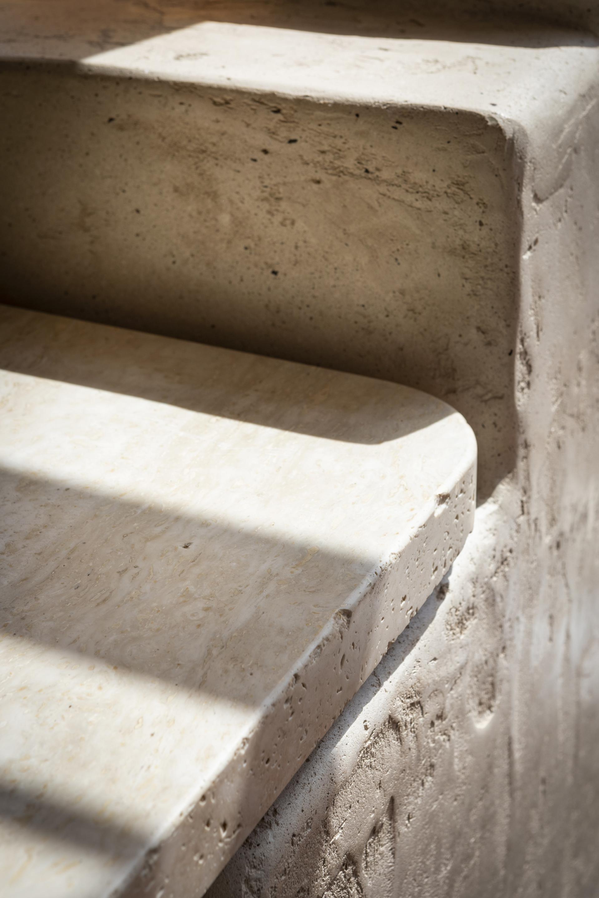 Detail of smooth, circular-edge stone surfaces, showcasing sustainable materials in a contemporary retail environment.