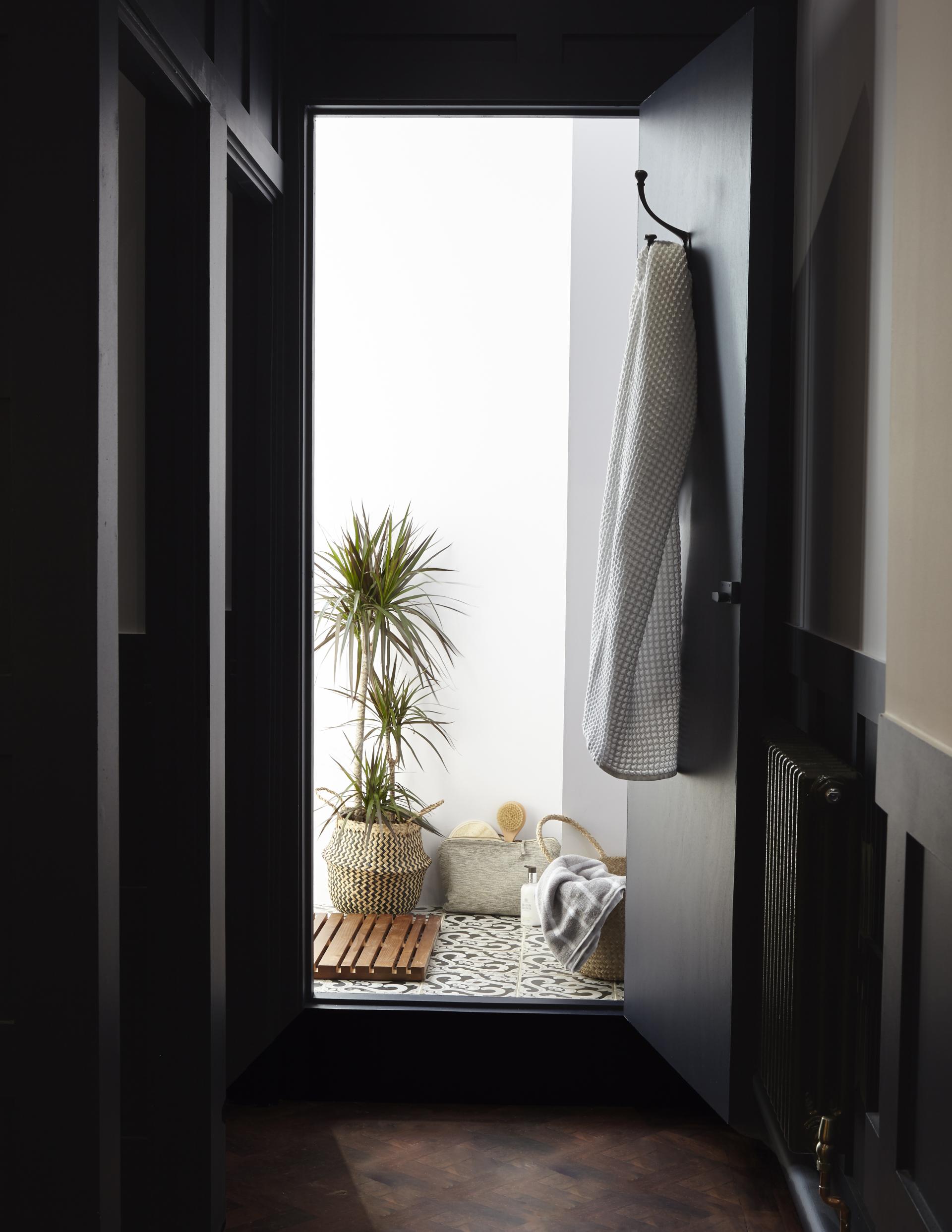 Chic loft-style entryway featuring a textile-wrapped towel, potted plant, and modern decor elements.
