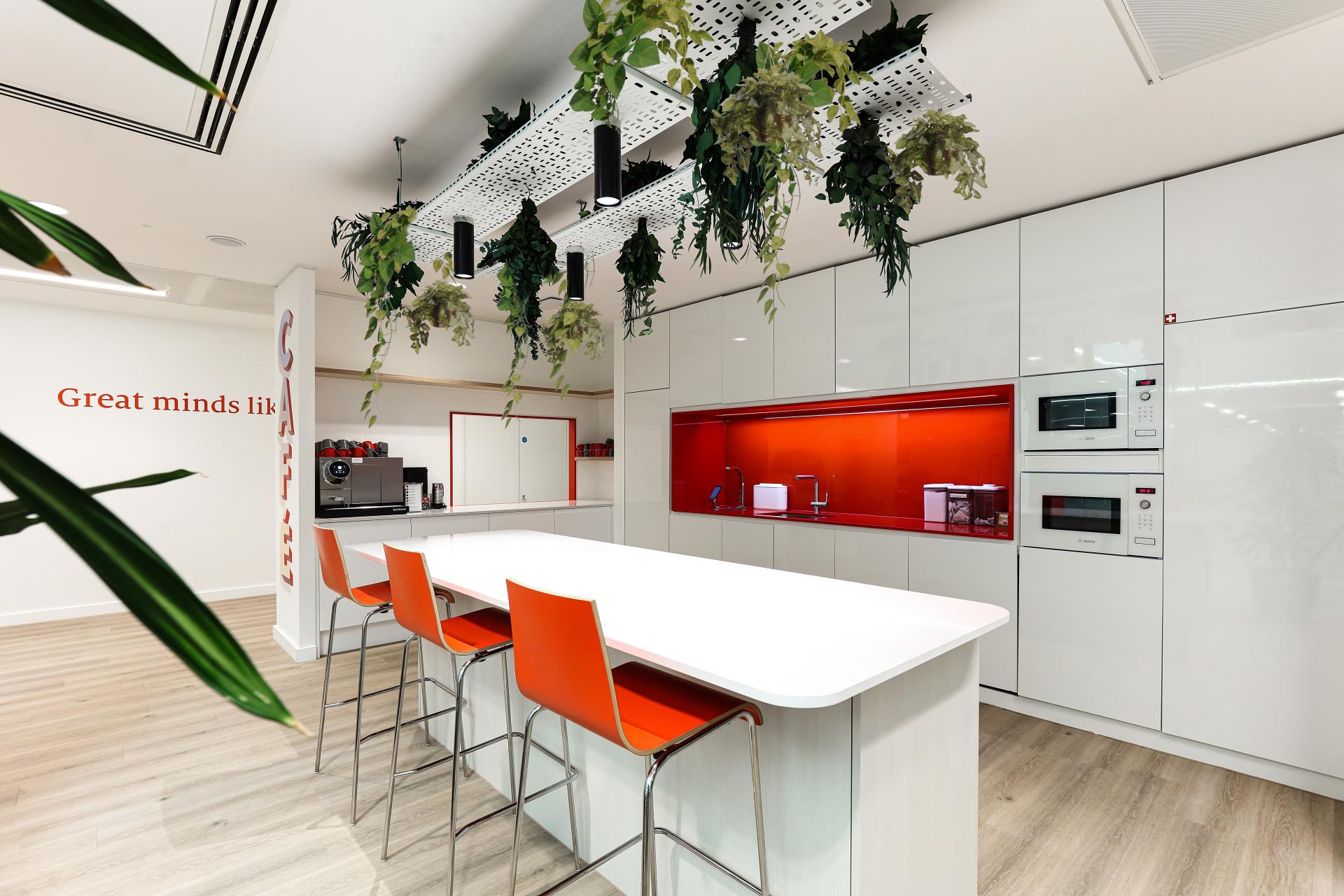Modern workspace featuring a structured kitchen design with vibrant colors, plants, and sustainable materials at The Economist Group.