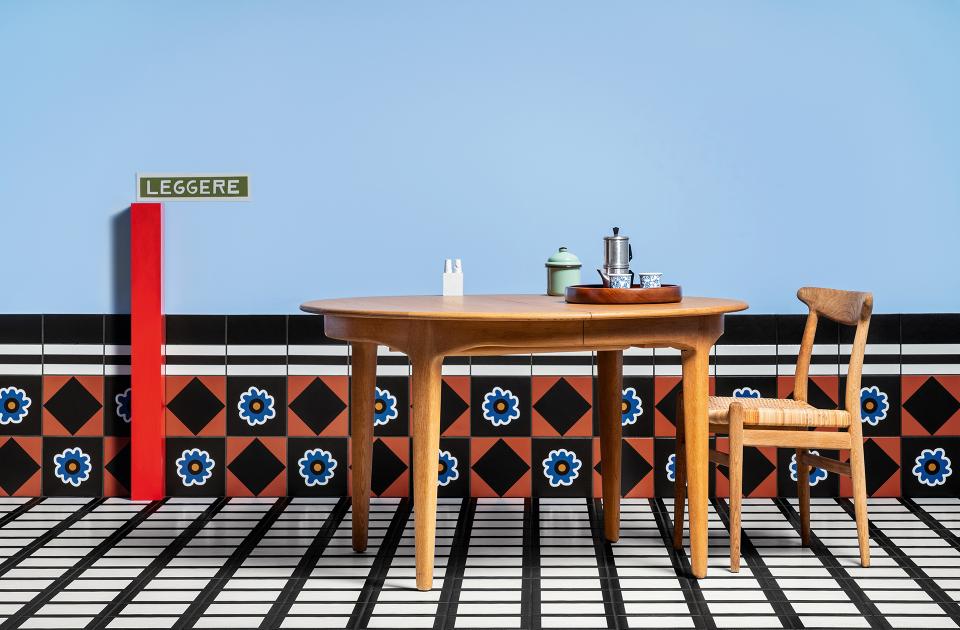 Stylish dining setup featuring a wooden table, a chair, and decorative tiles, showcasing Casa Ceramica's unique design approach.