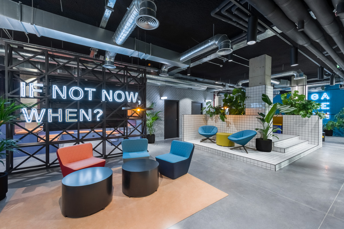 Vibrant co-working space at The Student Hotel Barcelona, featuring modern seating, playful decor, and greenery.