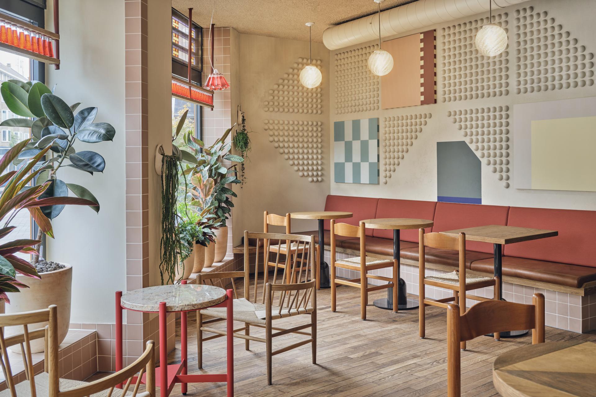 Charming interior of Volare trattoria in Amsterdam, featuring vibrant decor, cozy seating, and lush plants reminiscent of the Amalfi Coast.