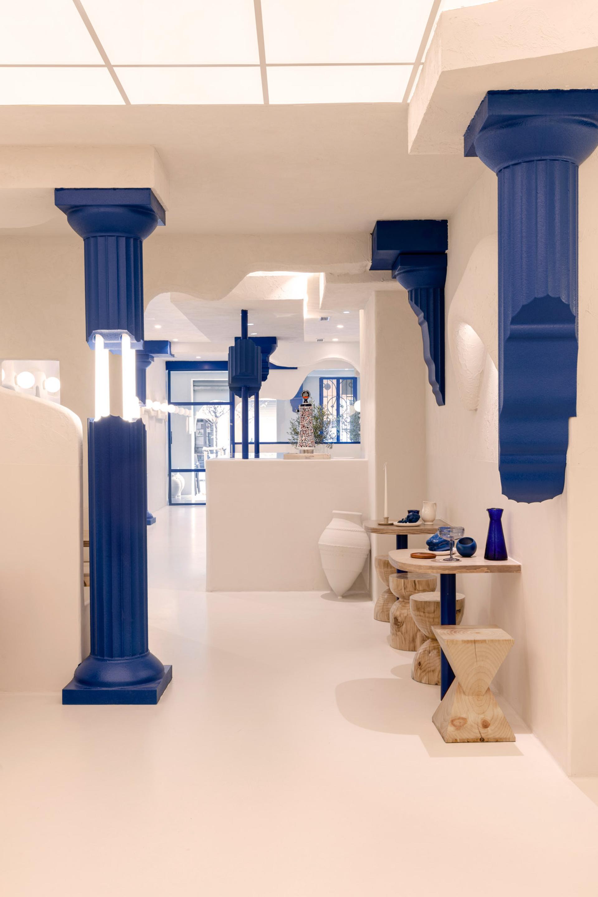 Contemporary interior design of Egeo restaurant features traditional Greek elements with modern blue accents and sculptural decor.