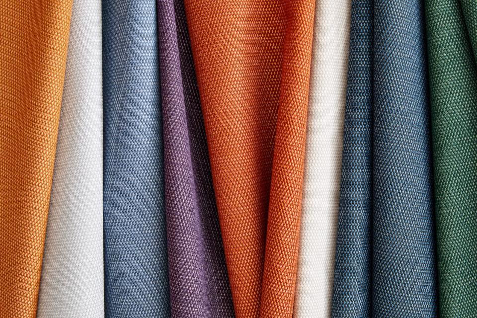 A vibrant display of Supreen performance upholstery fabrics in various colors and textures, showcasing durability and style.