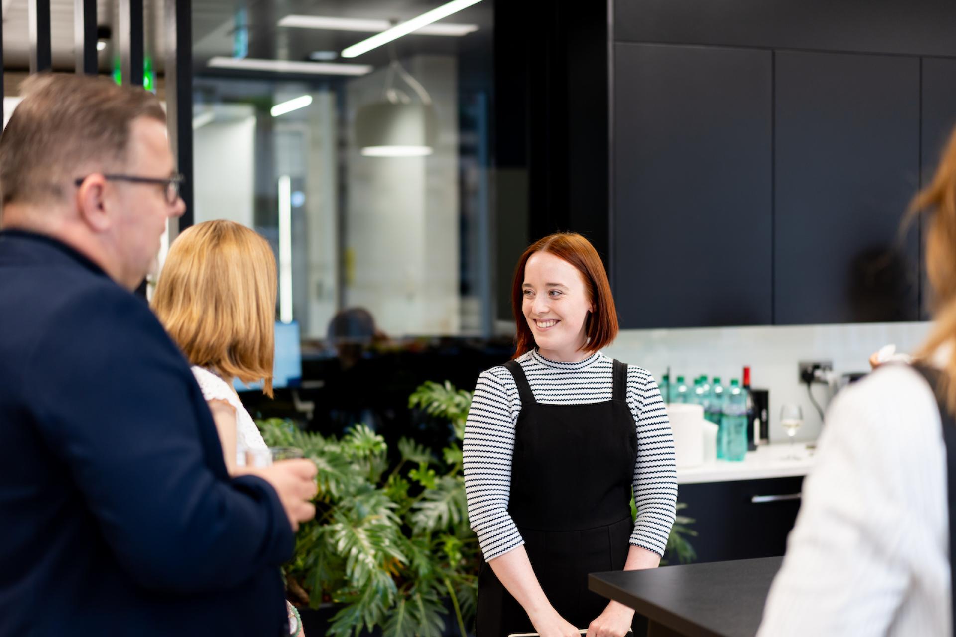 Engaged employees in a modern workspace discussing technology and collaboration in a forward-thinking environment.