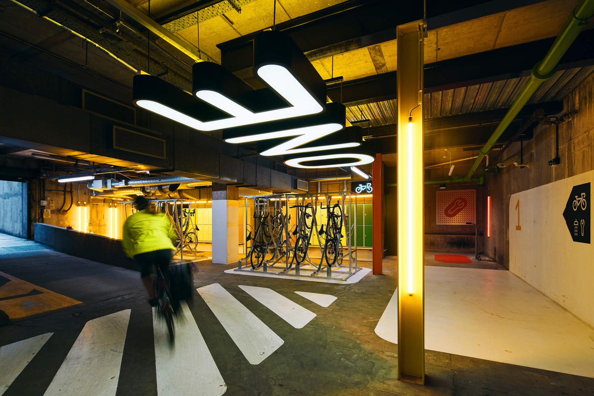 Modern bike parking facility featuring illuminated signage, bike racks, and eco-friendly design elements.