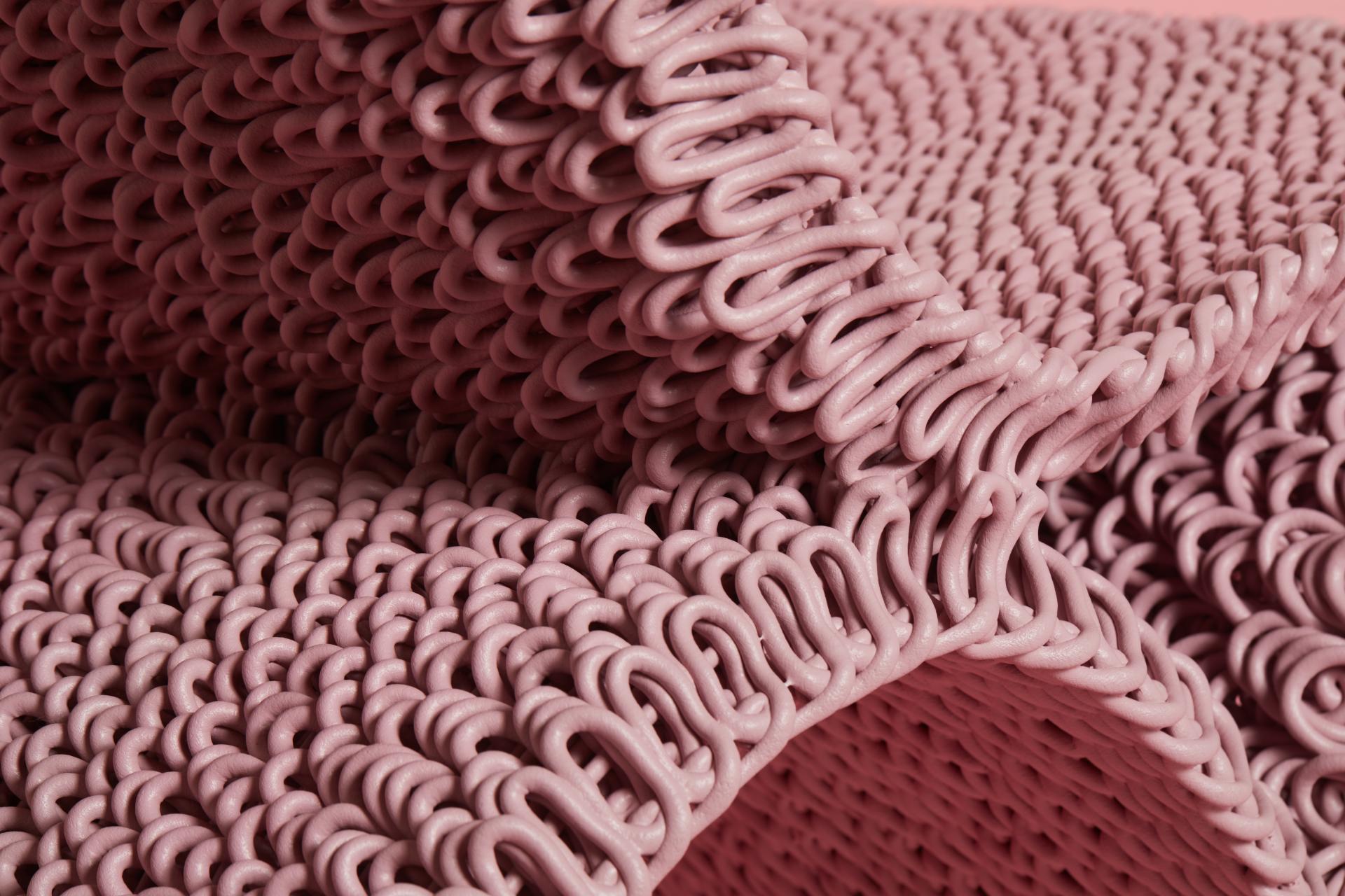 Close-up of pink 3D-printed textile showcasing unique, intricate loops, highlighting innovative design in sustainable materials.