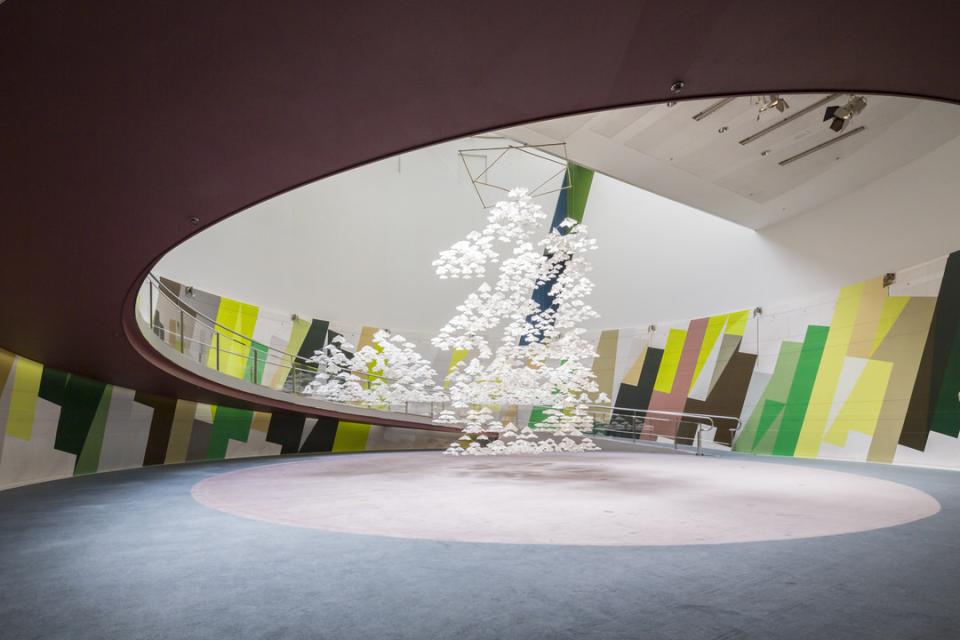 Unique installation featuring white cascading shapes, surrounded by vibrant geometric wall art in a modern interior space.